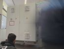 Workers Inspecting Industrial Electrical Cabinet in Factory Setting