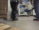 Workers Handling Equipment in an Industrial Setting with Wooden Pallets