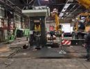 Aufbau von Industriemaschinen in einer Fabrik mit Arbeitern und schweren Ger&auml;ten