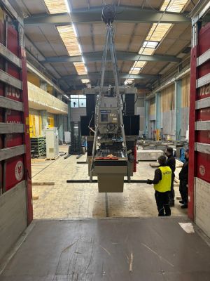 Industrial Machine Lifted by Crane in a Warehouse Environment