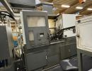 Industrial Metalworking Machine in Factory With Ventilation System and Nearby Chair
