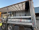 Industrial Loading Setup Inside Open-Walled Truck Near Warehouse Facility