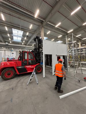 Industrial Warehouse Scene with Worker and Red Forklift in Operation