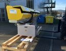 Gelbe Industrieausr&uuml;stung auf Holzpalette im Freien in der N&auml;he eines modernen Geb&auml;udes