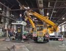 Yellow Crane Lifting Heavy Equipment Inside a Spacious Industrial Warehouse