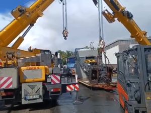 Heavy Equipment Lifting by Dual Cranes at a Construction Site