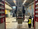 Industrielle Maschine mit Kran in einer Lagerumgebung angehoben