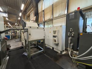 Industrielle Fertigungsanlagen in einer ger&auml;umigen Fabrikhalle mit aktivem Maschinenpark