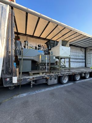 Auf einen Lastwagen verladene Industriemaschinen auf einem offenen Fabrikgel&auml;nde