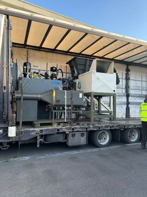 Verladung von Industriemaschinen auf einen offenen Lkw zur Darstellung des Transportprozesses