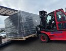 Gabelstapler, der ein verpacktes Frachtpaket f&uuml;r den Transport auf einen Lkw l&auml;dt