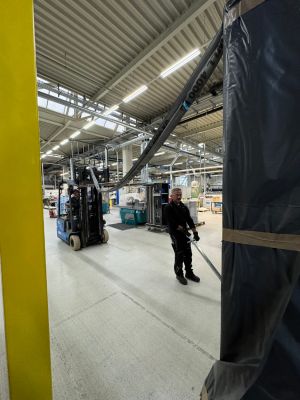 Arbeiter, der einen Gabelstapler in einer belebten industriellen Lagerhalle bedient