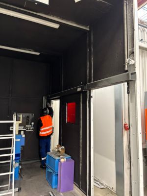 Arbeiter beim Einstellen des T&uuml;rrahmens in einer modernen industriellen Werkstattumgebung