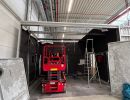Rote Scherenhebeb&uuml;hne in einem im Bau befindlichen Lagerhaus mit freiliegenden Deckenkonstruktionen