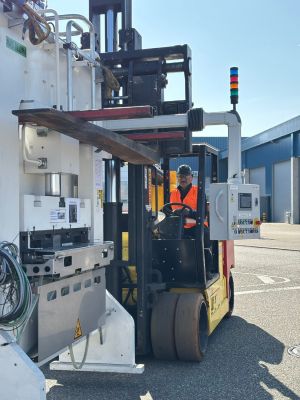Arbeiter, der einen Gabelstapler im Industriegebiet bedient und schwere Maschinen handhabt