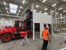 Industrielager-Szene mit Arbeiter und rotem Gabelstapler im Einsatz
