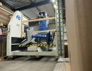 Industriemaschinen im Lager mit gestapelten Materialien und Schutzabdeckungen